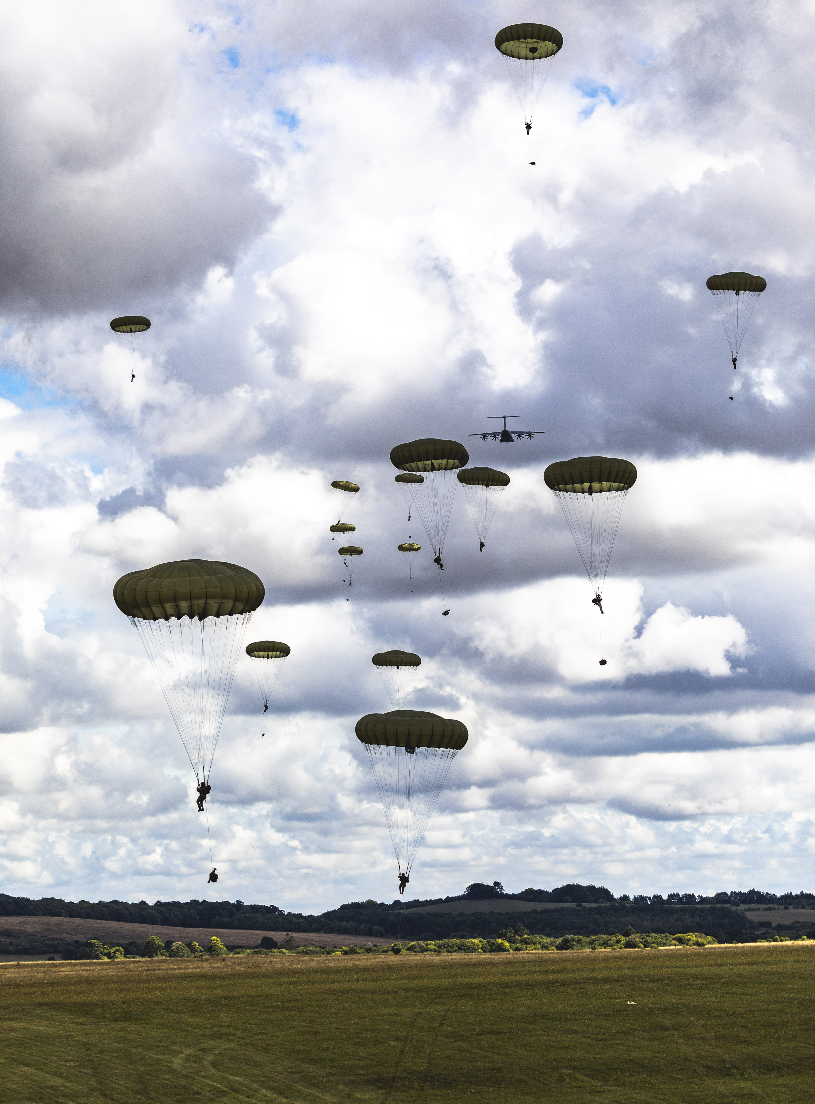 Image shows parachutist coming in to land on the ground.